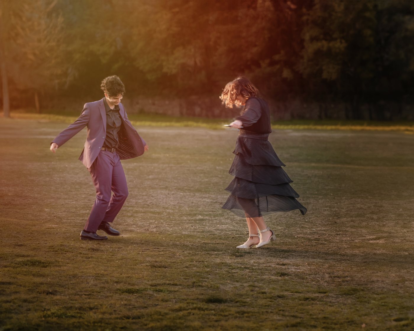 Aurita's children dancing together in a field at sunset
